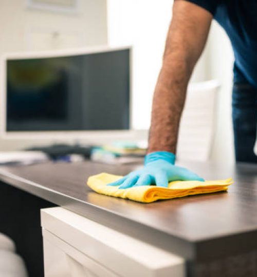 Man disinfecting an office desk