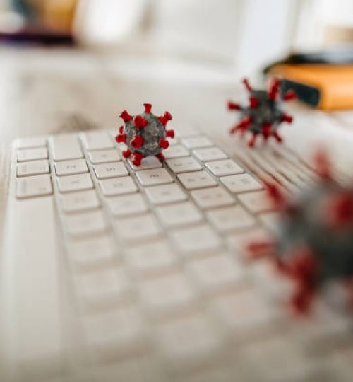 Close up model of corona virus on desk and keyboard in office